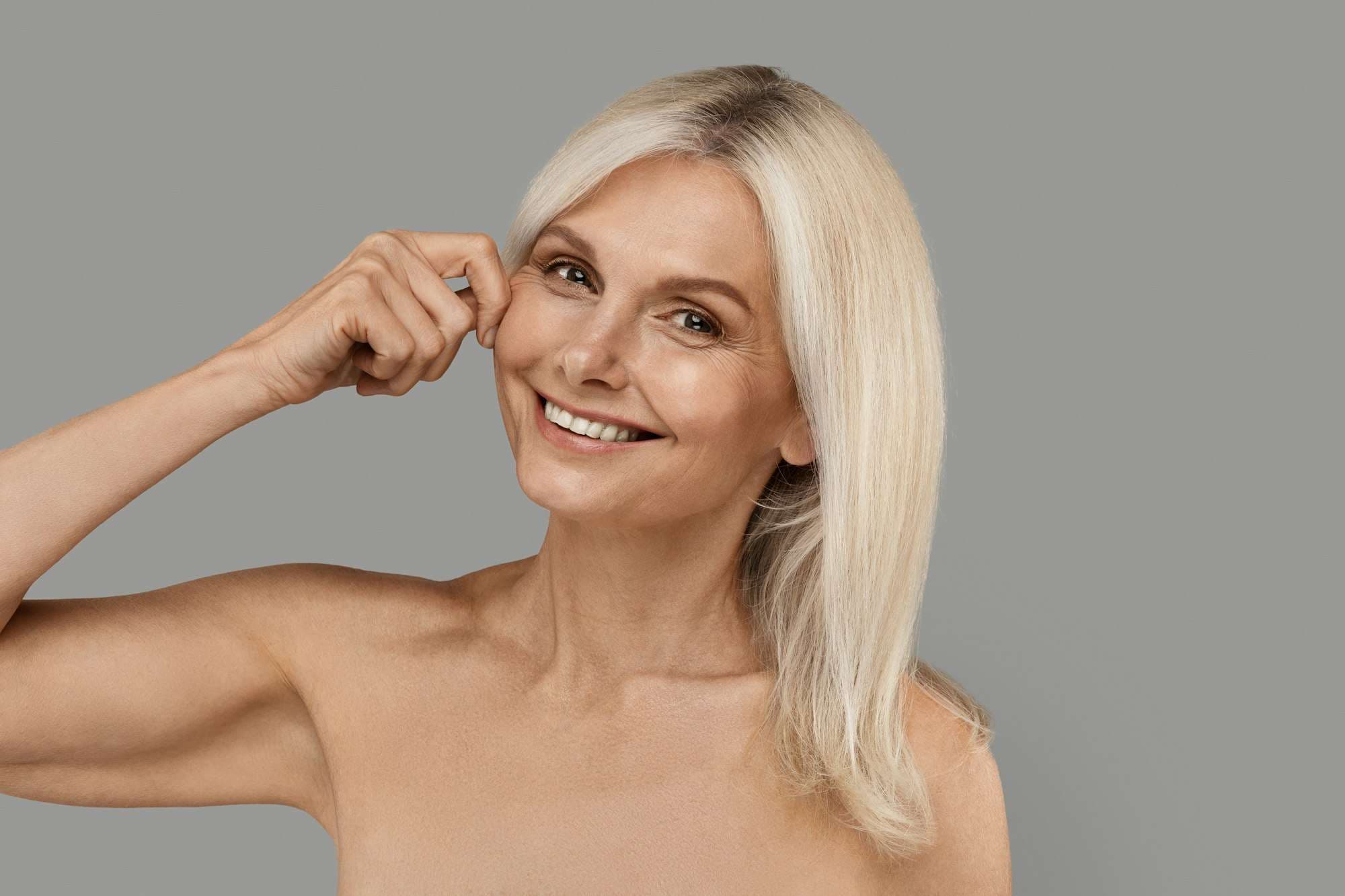Mature woman with firm tightened skin touching her cheek