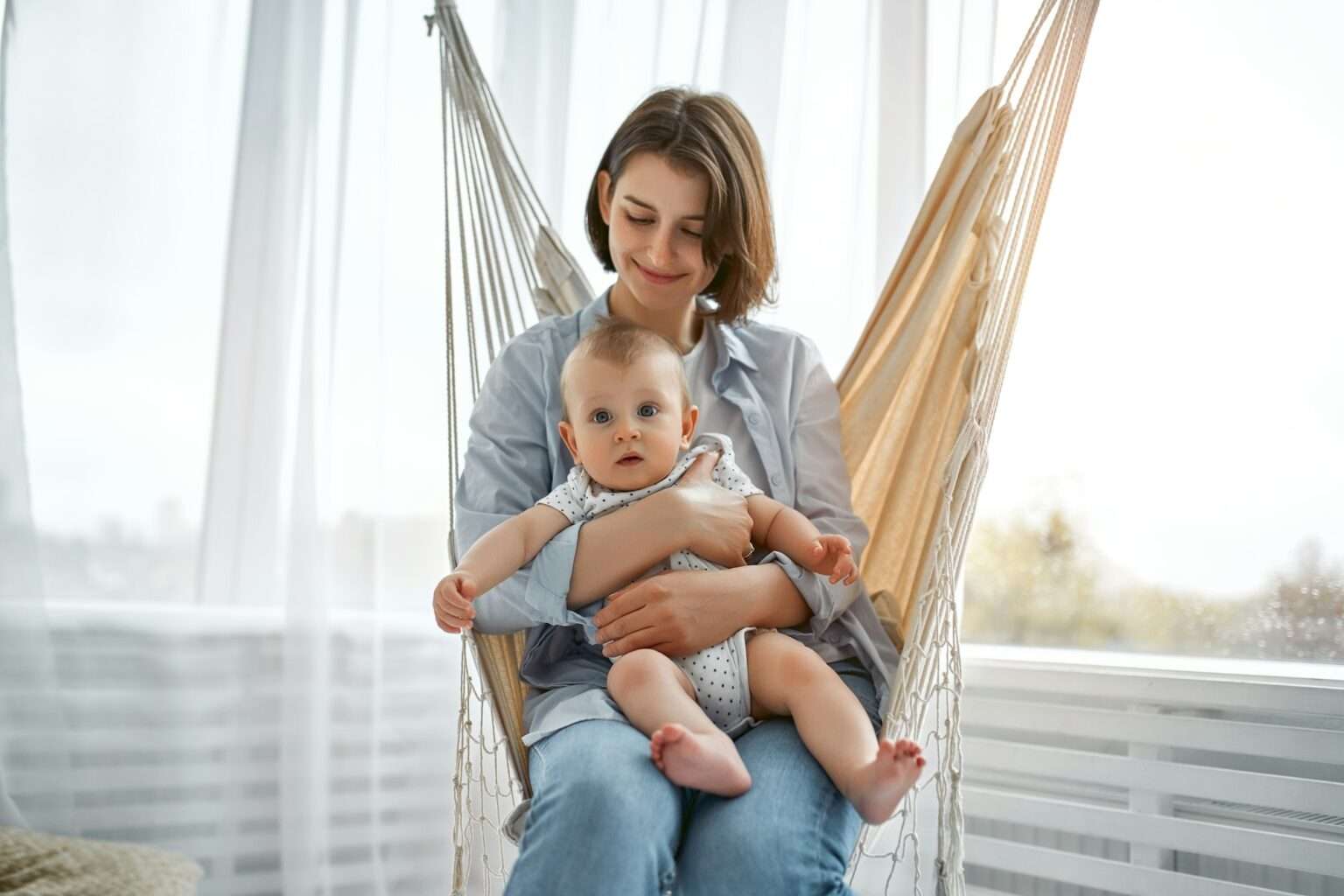 Happy mother holding her baby after non-surgical mommy makeover