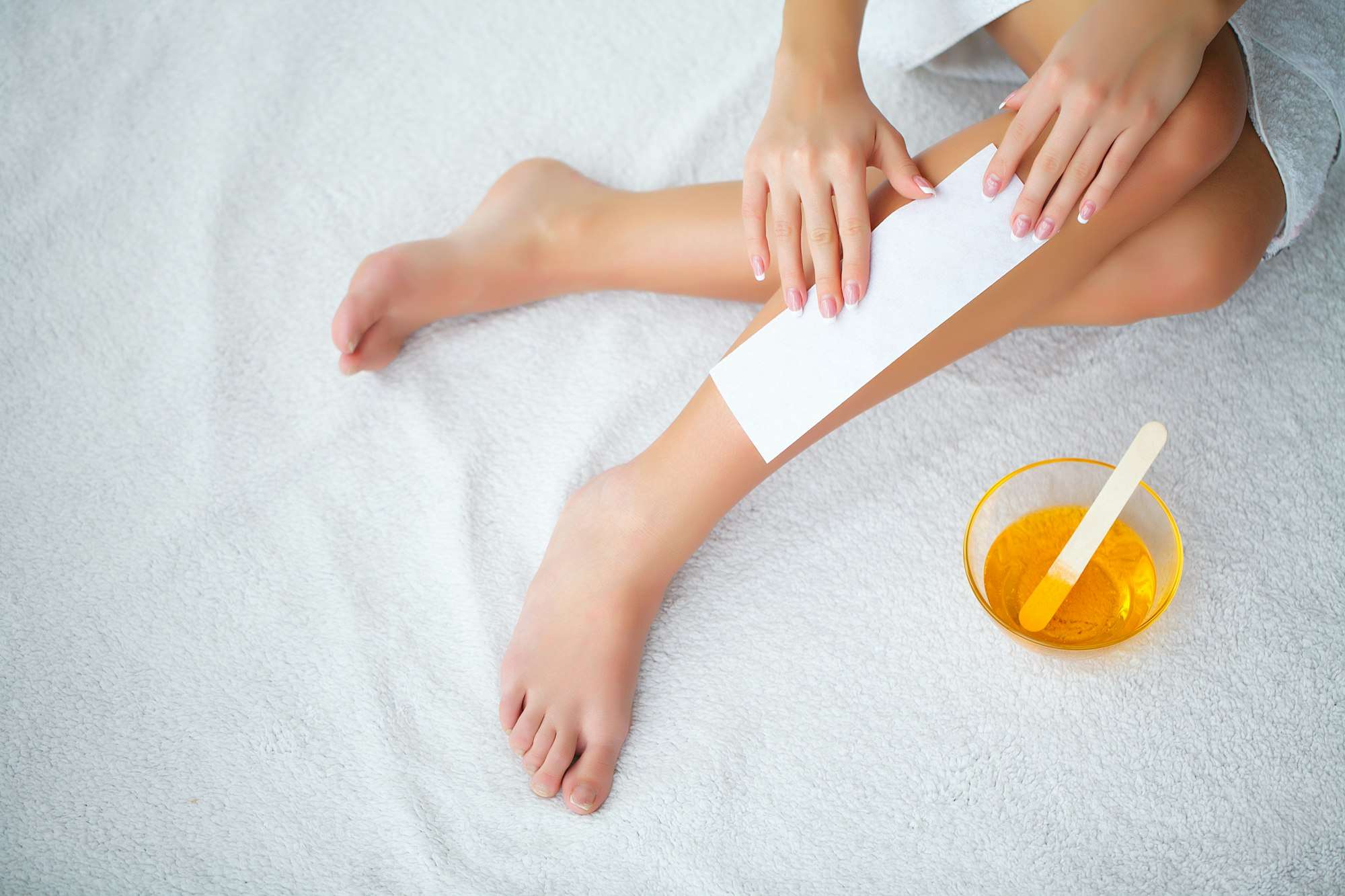 Professional leg waxing treatment with wax strip