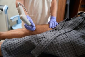 Certified doctor using innovative shockwave therapy device on patient