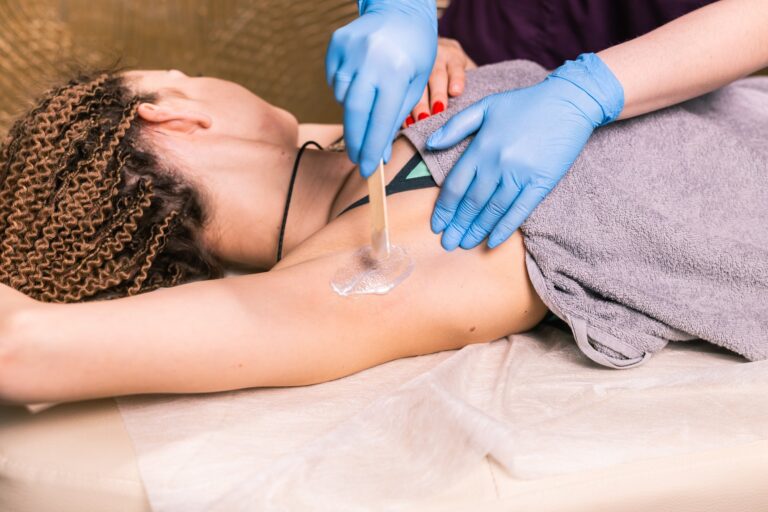 Waxing woman armpit. Salon wax beautician epilation procedure. Waxing female body for hair removal