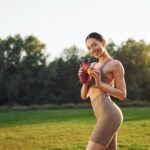 Diet and weight loss conception. Young woman in yoga clothes is outdoors on the field